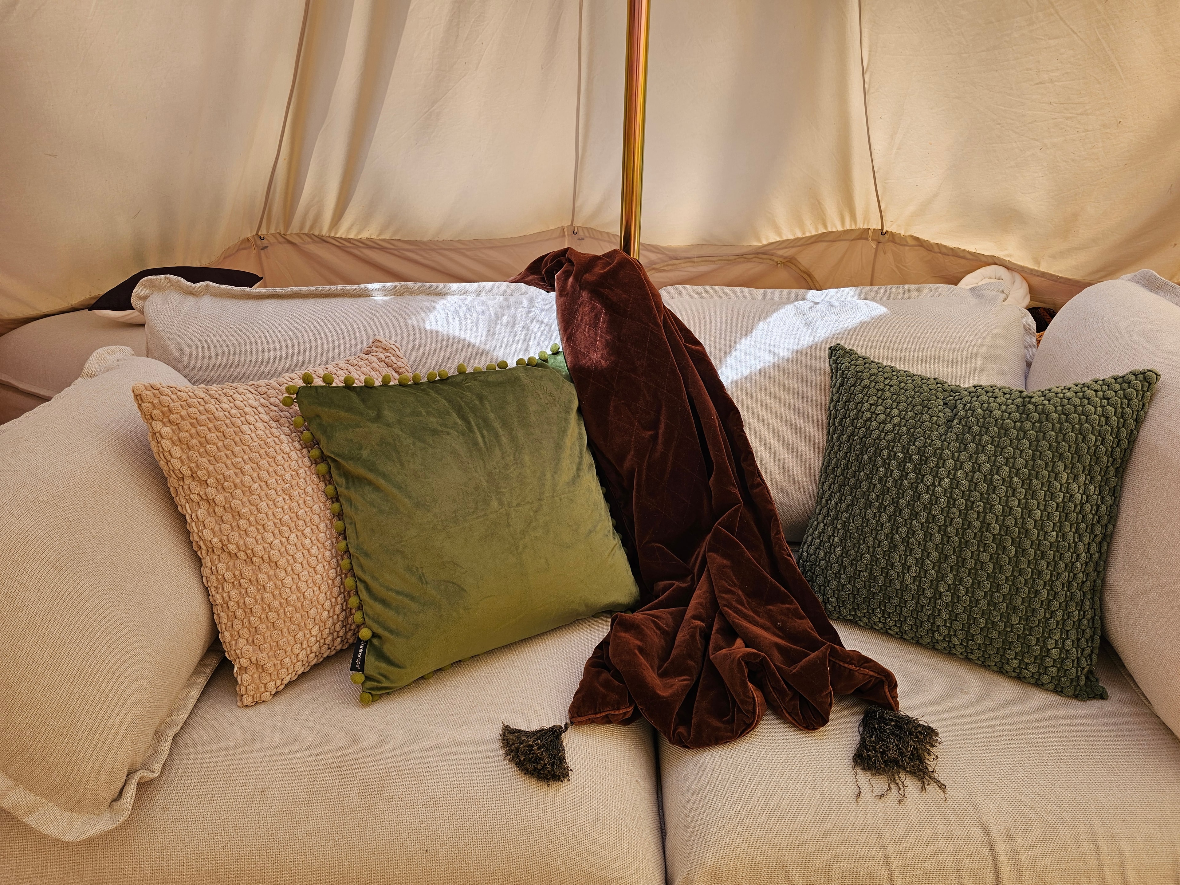 Glamping tent bed with decorative pillows
